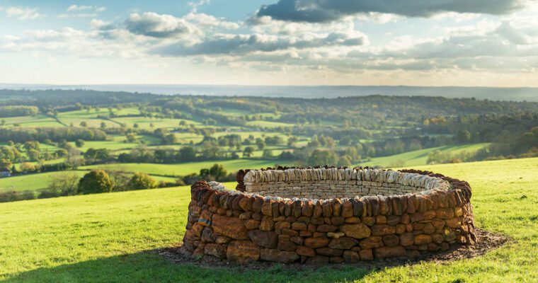 Stone sculpture overlooking fields in the background