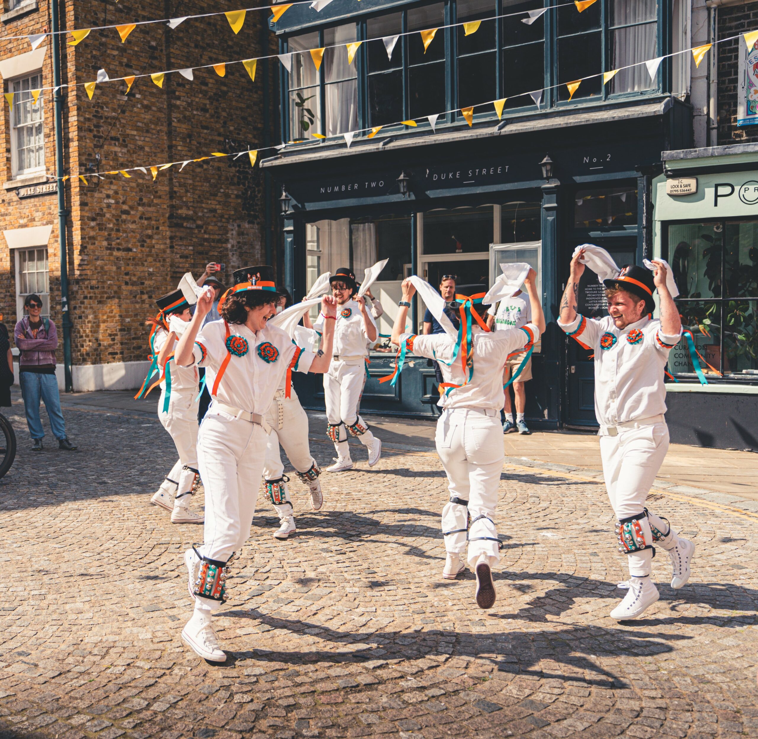 Bower Street Morris dance in a circle on cobbled street